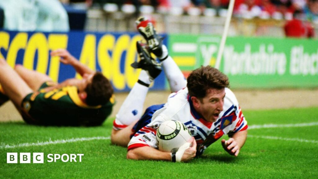 Shaun Edwards looks to the referee as a group of Australia players gather, with Bradley Clyde flat out on the ground