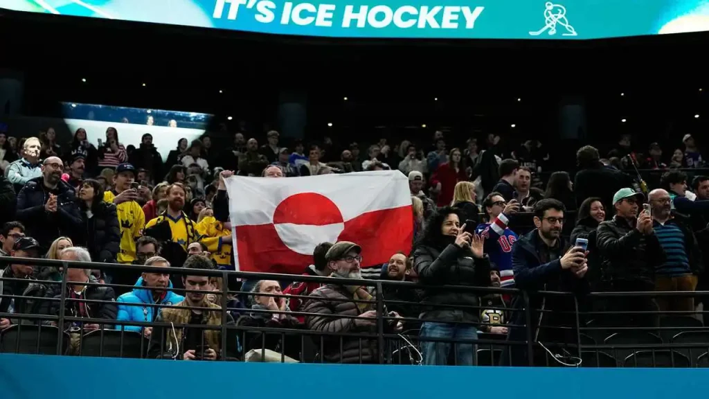 Supporters display Greenland's flag in response to US victory over Denmark in Olympic hockey match.