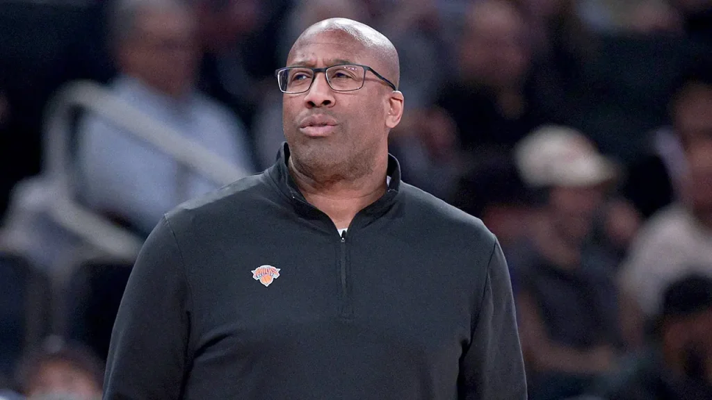 Knicks coach Mike Brown humorously answers a reporter's ringing phone during news conference.